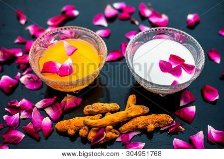 Milk Face Pack On Black Shiny Surface Consisting Of Raw Milk,turmeric Or Haldi And Badam In A Glass
