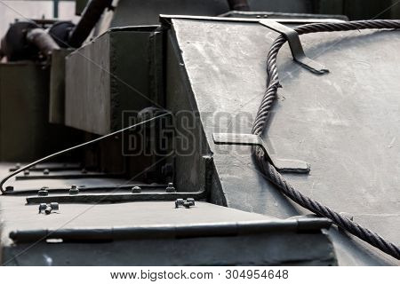 Close-up Of Armor Protection Of A Tank (tracked Howitzer) With A Transport Cable At The Front. Dark 