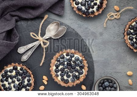 Top View On Wholegrain Blueberry Tarts With Vanilla Cream On Dark Background