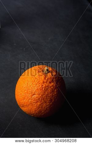 Isolated Orange With Dramatic Lighting On Dirty Chalkboard Background