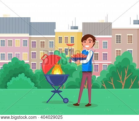 Happy Smiling Man With A Barbecue Tools Preparing Grill Sausages In Outdoor Landscape Summer Time. P