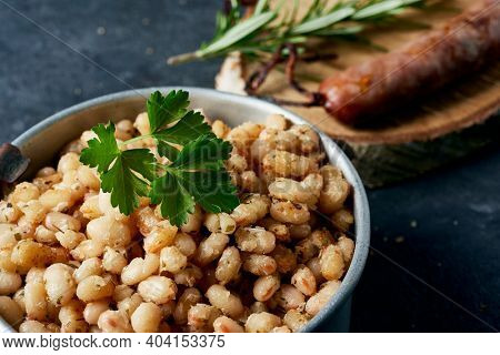 botifarra amb mongetes, sausage and fried white beans, a traditional dish of catalonia, spain, served in an old metallic lunch box
