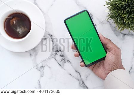 Hand Holding Smart Phone With Empty Screen On Tile Backgorund
