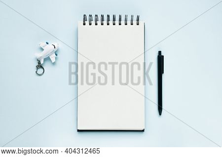 Open Notepad, Airplane, Pen On Blue Background. Travelling To Do List, Vacation And International Fl