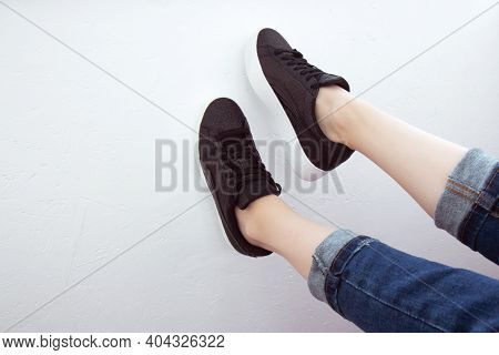 Female Feet Seen From Above. Selfie For Any Use. Foot And Legs In Black Sneakers And Jeans. Foot Rai