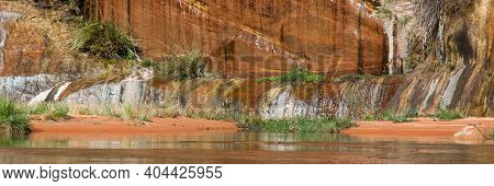 A Small Orange Sand Beach Sits Between The Sandstone Walls Of Glen Canyon And The Mighty Colorado Ri