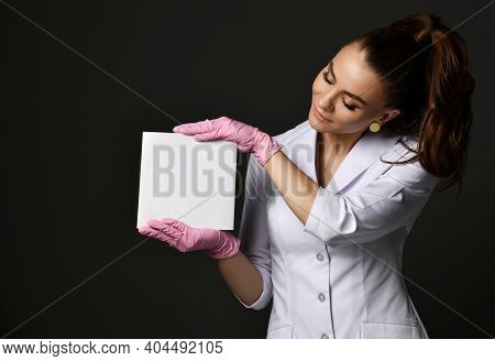 Young Smiling Pretty Woman Doctor Therapist In White Uniform And Protective Latex Gloves Holding Bla