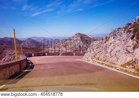 View Of Beautiful Mountain Landscape Through The Windscreen On A Sunny Day. Driving A Car On Mountai