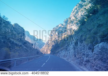 View Of Beautiful Mountain Landscape Through The Windscreen On A Sunny Day. Driving A Car On Mountai