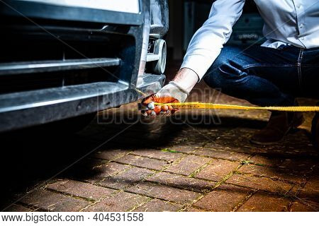 A Male Hand Attaching A Towline To A Car Towing Eyelet.