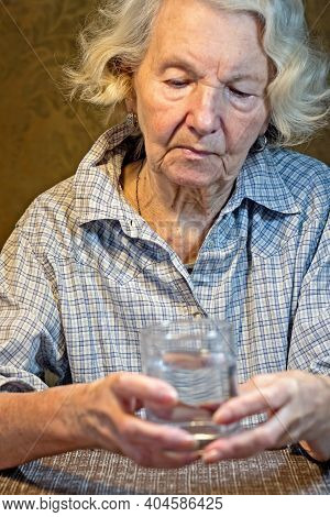 Old Women's Hands Holding Glass Of Water.