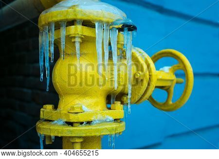 Winter. The Yellow Gas Valve Is Covered With Ice And Icicles.