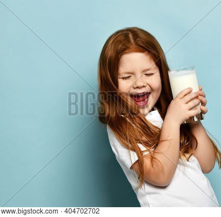 Cheerful Happy Small Cute Girl In White T-shirt Standing With Glass Of Milk Yogurt Kefir Feeling Exc