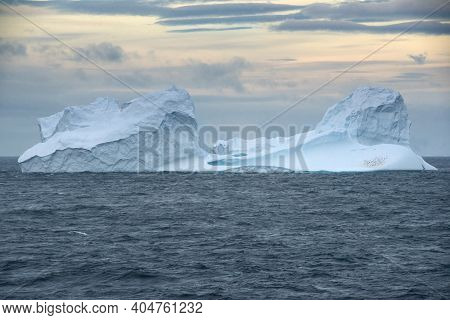 Floating Iceberg With A Colony Of Gentoo Penguins At Sunset In Bransfield Strait Near The Northern T