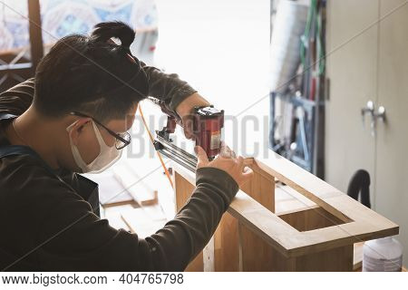 Entrepreneur  Woodwork Holding A Tacker To Assemble The Wood Pieces As The Customer Ordered