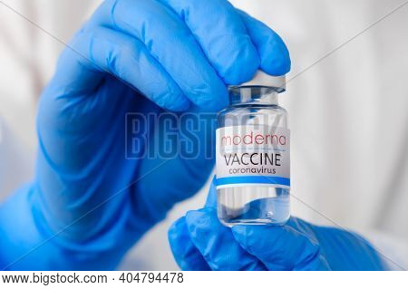 Moderna Coronavirus Vaccine In Doctors Or Nurses Hands In Blue Rubber Gloves. Prevention Of Sars-cov