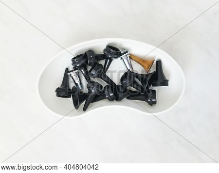Funnel For Examination Of Ear In White Plastic Plate. Black Plastic And Metal White And Orange Color