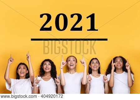 Year 2021. Five Multicultural Ladies Pointing Fingers At Number 2021 Above Head Planning Achievement