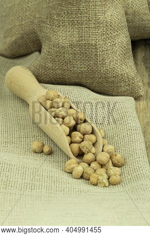 Chickpea Grains In A Bag On A Wooden Background With Space For Text. Chickpea Seeds On A Wooden Spoo