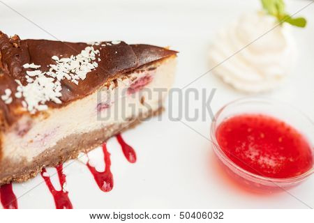 Cheesecake with chantilly cream and coulis close up served in classy restaurant