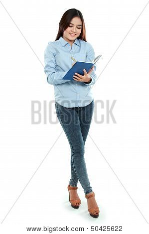 Portrait Of Student Holding Book And Writing.