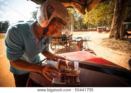SIEM REAP, CAMBODIA - DEC 13: Unidentified cambodian moto-rickshaw in Angkor Wat, Dec 13, 2012 on Siem Reap, Cambodia. Angkor is the country's prime attraction for visitors.