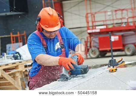 Builder worker with power tool circular saw machine cutting plastic parts at construction site