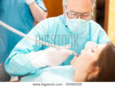 Dentist doing a dental treatment on a female patient