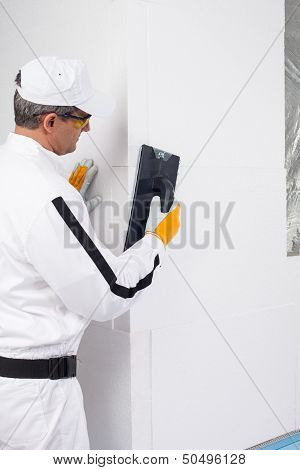 Worker Rasping The Corners Of Insulation Panels