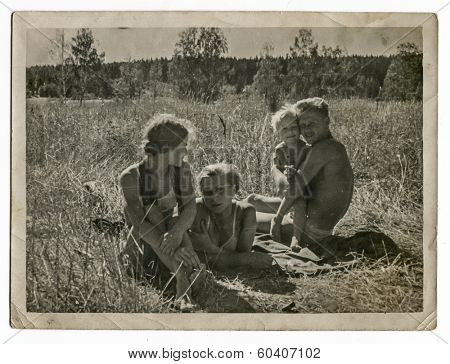 MOSCOW, USSR - CIRCA 1970s : An antique photo shows family resting on the meadow. 