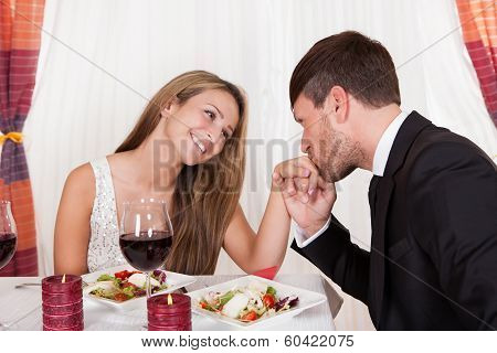 Man Kissing A Womans Hand At A Romantic Dinner