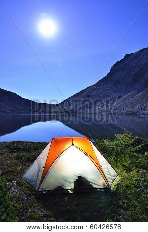 Tent On Camping Ground Near The Lake At Night In Moonlight