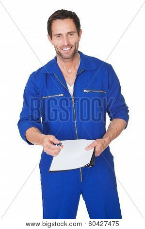 Portrait Of Happy Automechanic Writing Invioce