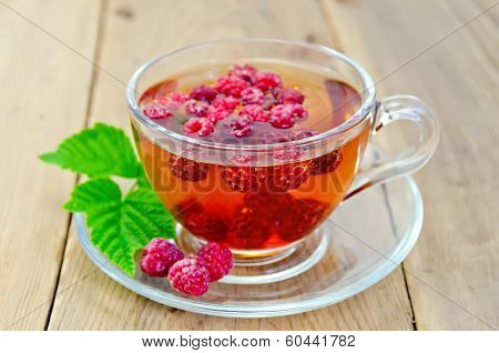 Tea With Raspberry And Leaf In A Cup On Board