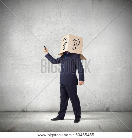 Businessman using mobile phone wearing carton box on head