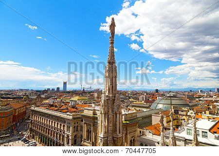 A statue of the Dome of Milan cathedral with the city view in summer.