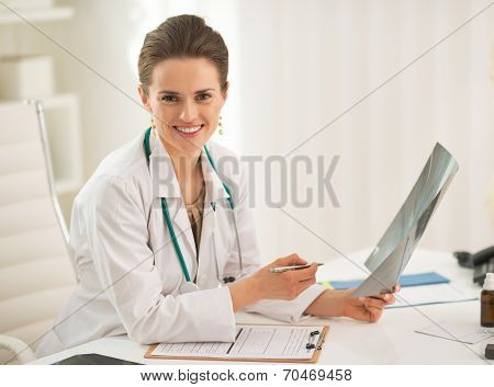 Portrait Of Happy Doctor Woman Holding Fluorography In Office