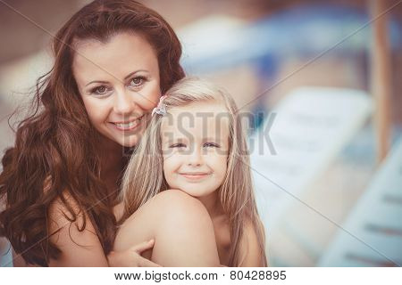 Happy mom and her adorable little daughter during summer vacation on the beach