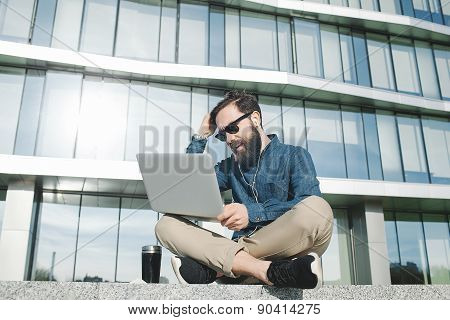 Businessman In Sunglasses With Laptop Holding Head Outdoors