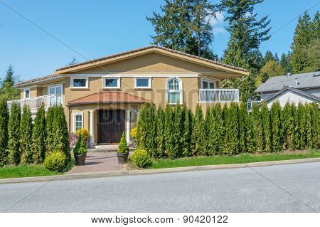 Cozy house with beautiful landscaping on a sunny day. Home exterior.