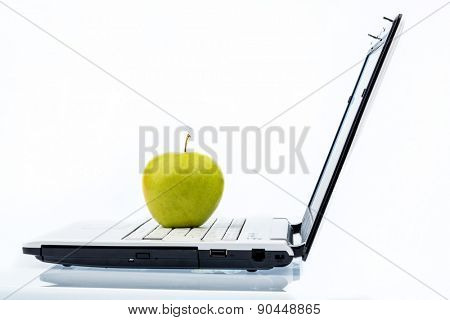 an apple is on the keyboard of a computer. symbolic photo for healthy and vitamin-packed snack.