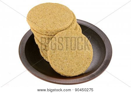 A dish of gluten free crumbly rough Oatcakes, isolated on white background