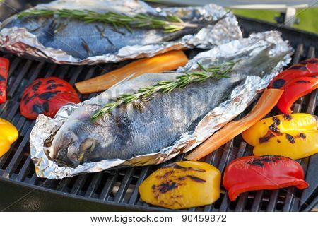 Fresh dorado fish and bell pepper grill cooking outdoors