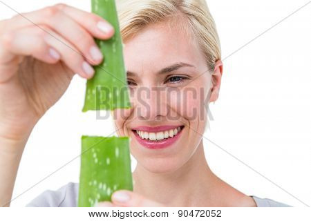 Attractive woman snapping aloe vera leaf on white background