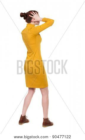Back view of shocked woman in dress .   upset young girl. Rear view people collection.  backside view of person.  Isolated over white background. A woman in a dress is shocked by what he saw.