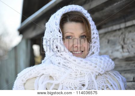 The Russian Woman In  Shawl Warms Hands Near An Izba