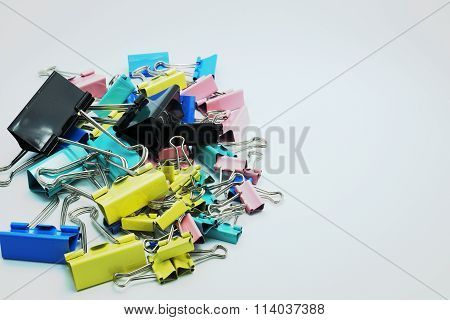 Various size and colorful paper clips. Selective focus on black at center. Gray backgrou