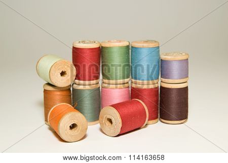 Many Spools Of Thread Of Different Colors On A White