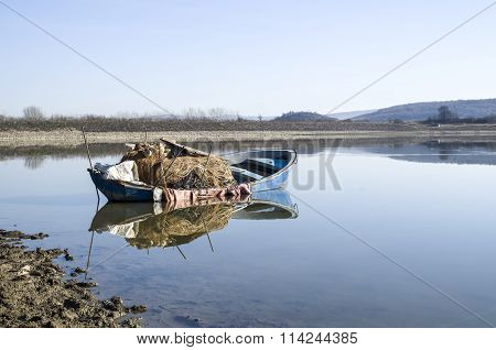 Lonely Fishing Boat In Lake With Reflection