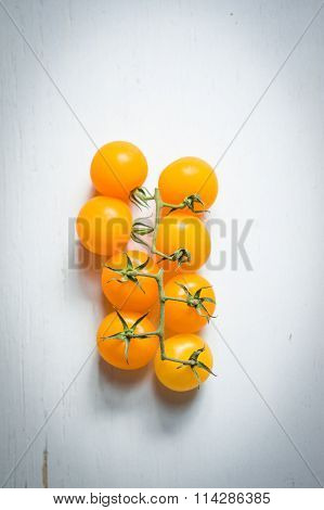 Yellow Tomatoes On The Vine On Wooden Background